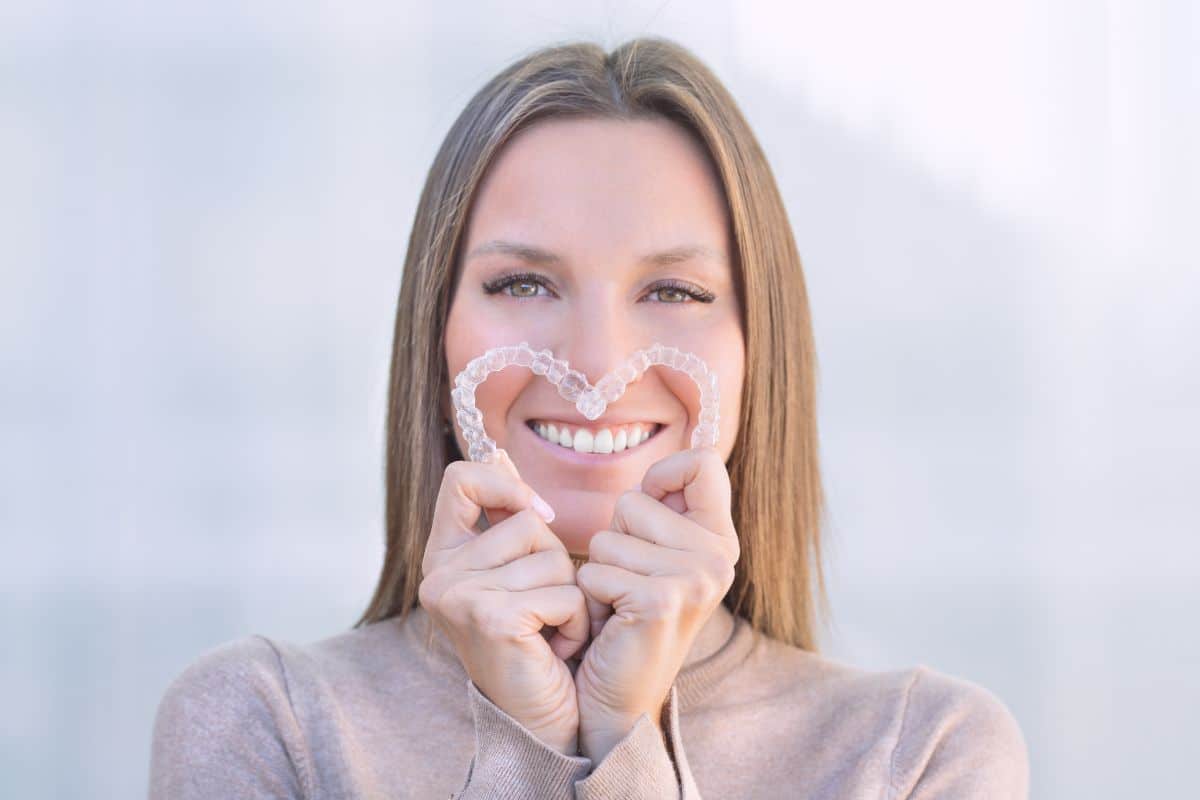 woman holding Invisalign pair