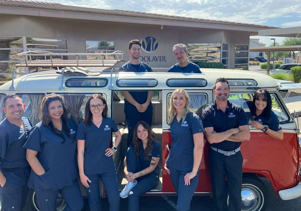 Dr. Chris Woolaver and his dental team eight people standing infront of a van.