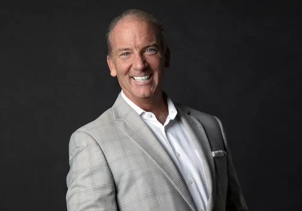 A man in Suit standing and smiling after Invisalign treatment in Phoenix