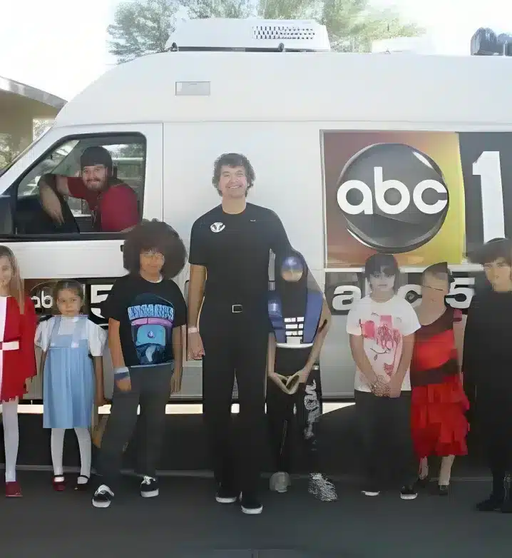 A member of the Woolaver orthodontics standing with few kids